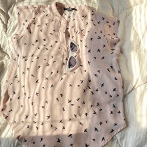 Soft pink sleeveless blouse.